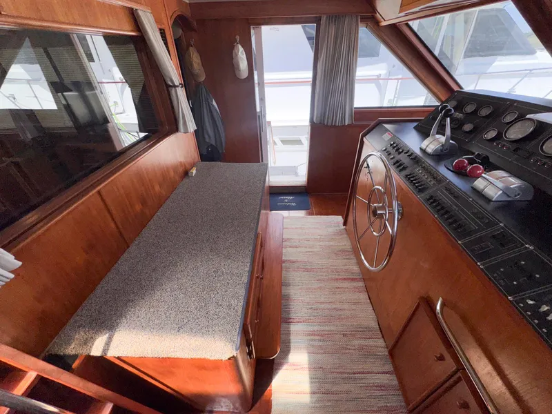 Slide: The Image of 1988 Chris-Craft 501 Motor Yacht interior with helm, steering wheel, and seating area. - 46