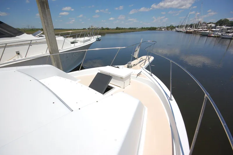 Slide: The Image of 1988 Chris-Craft 501 Motor Yacht docked in a serene marina under a clear blue sky. - 6