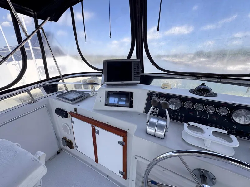 Slide: The Image of 1988 Chris-Craft 501 Motor Yacht helm with navigation instruments and steering wheel. - 9