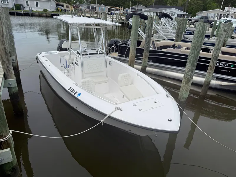 Slide: The Image of 2024 Aquasport 2200 Center Console boat docked in a marina. - 1