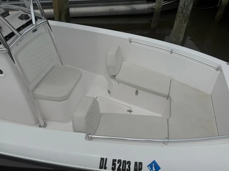 Slide: The Image of 2024 Aquasport 2200 Center Console boat interior with cushioned seating and sleek design. - 11