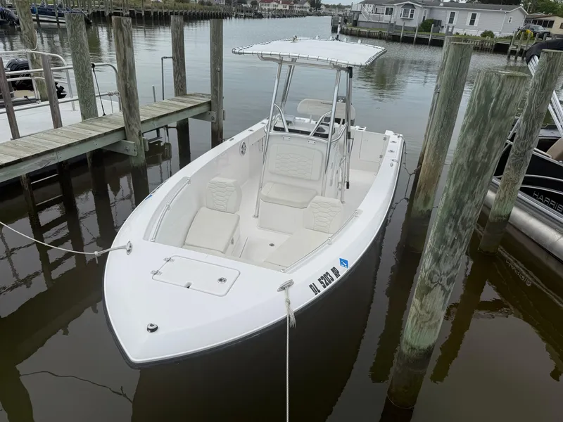 Slide: The Image of 2024 Aquasport 2200 Center Console boat docked in a marina. - 2