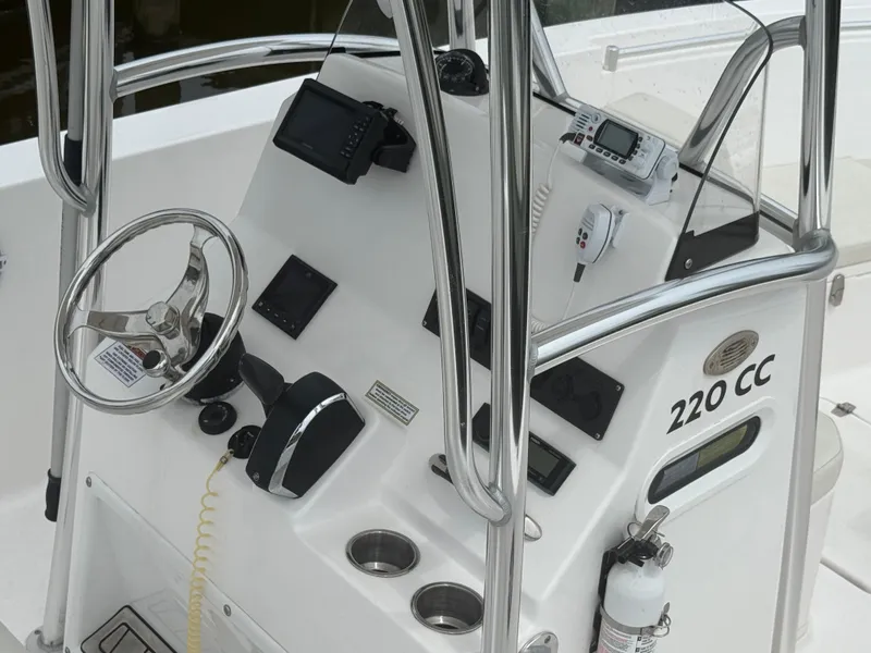 Slide: The Image of 2024 Aquasport 2200 Center Console boat dashboard with steering wheel and navigation equipment. - 6