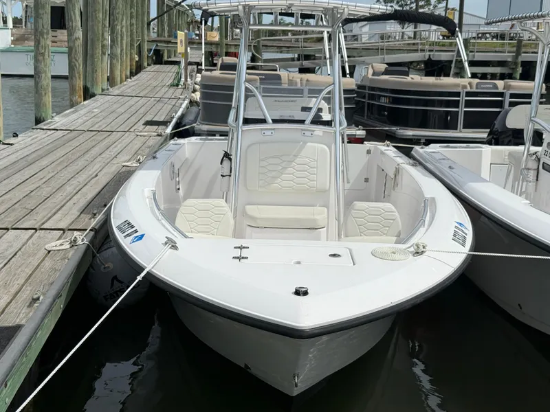 Slide: The Image of 2024 Aquasport 2200 Center Console boat docked at marina, featuring sleek design and spacious seating. - 11