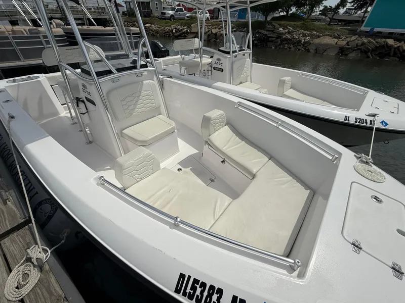 Slide: The Image of 2024 Aquasport 2200 Center Console boat with white seating, docked at a marina. - 5