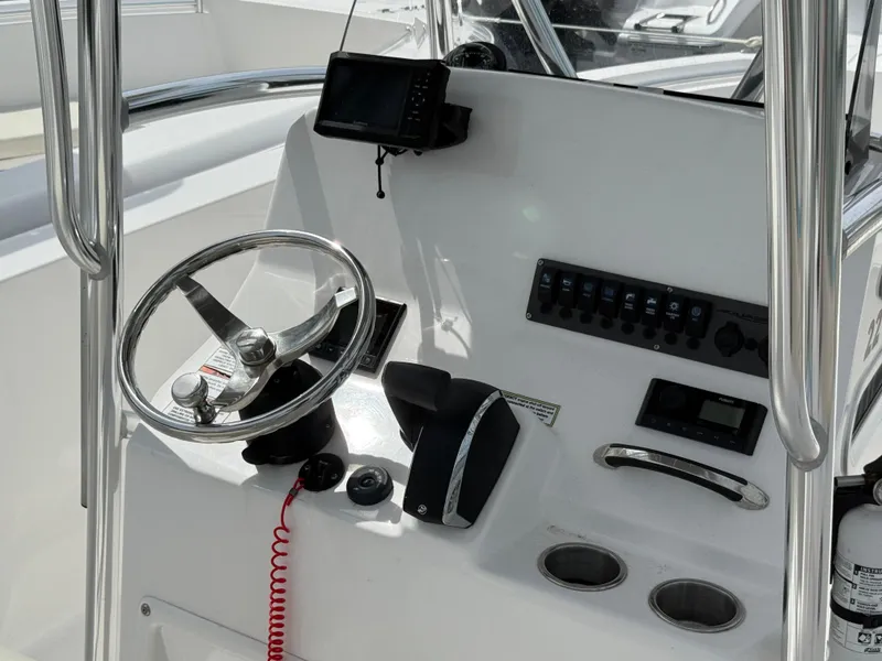 Slide: The Image of 2024 Aquasport 2200 Center Console helm with steering wheel and control panel. - 8