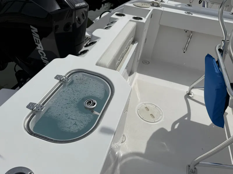 Slide: The Image of 2024 Aquasport 2200 Center Console boat interior with livewell and Mercury engine. - 9