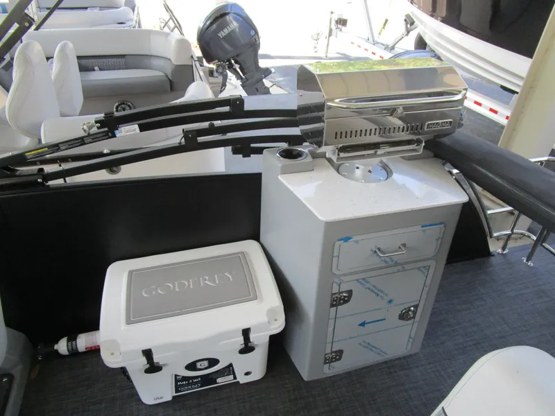 Slide: The Image of 2025 MONACO Monaco Cruise 235 C boat interior with grill and cooler setup. - 13