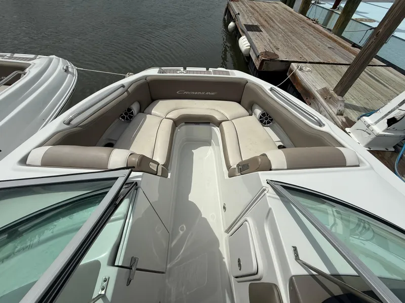 Slide: The Image of 2023 Crownline Eclipse E235 XS boat interior with beige seating at dock. - 5
