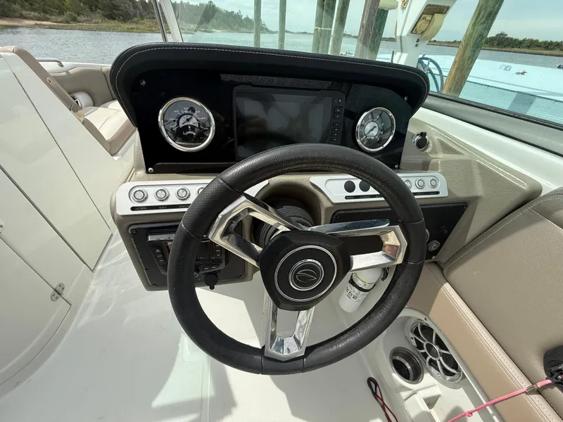 Slide: The Image of 2023 Crownline Eclipse E235 XS boat dashboard with steering wheel and controls. - 6