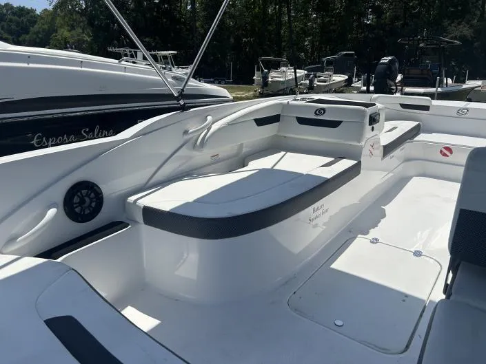 Slide: The Image of 2021 Hurricane SunDeck Sport 185 OB boat interior with seating and storage, docked outdoors. - 6