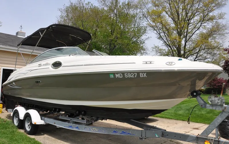 Slide: The Image of 2006 Sea Ray 240 Sundeck boat on trailer, parked outdoors. - 1