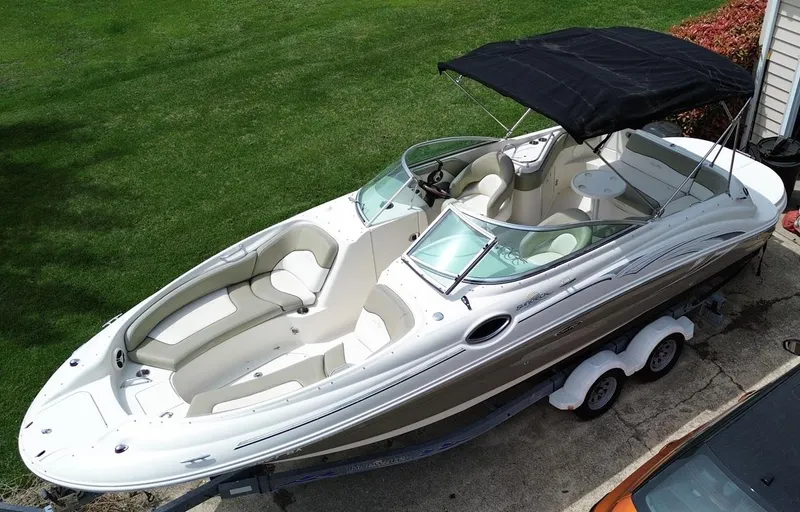 Slide: The Image of 2006 Sea Ray 240 Sundeck boat with canopy on trailer, parked on driveway. - 5