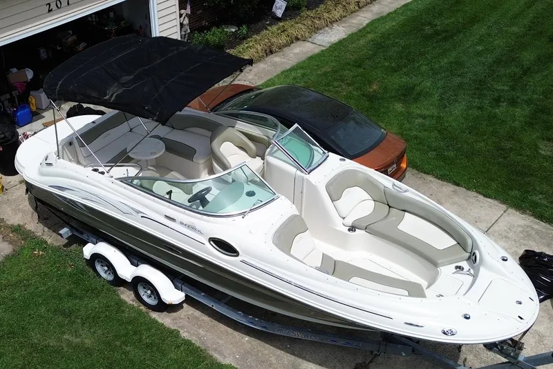 Slide: The Image of 2006 Sea Ray 240 Sundeck boat on trailer, parked in driveway, with black canopy. - 6