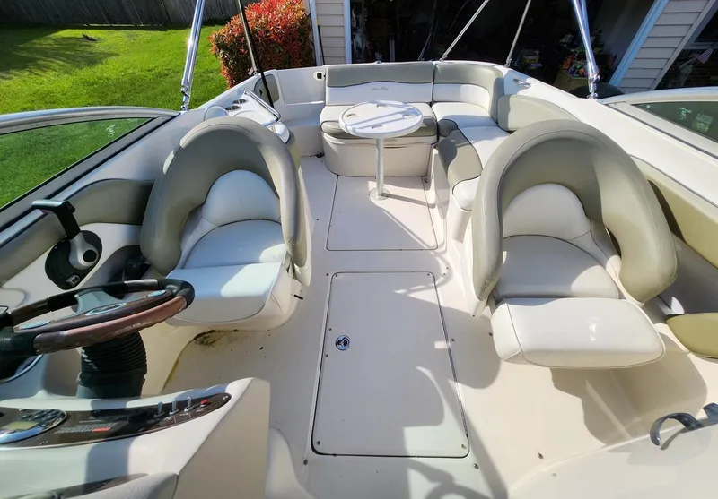 Slide: The Image of 2006 Sea Ray 240 Sundeck interior with seating and table, showcasing spacious and comfortable design. - 9