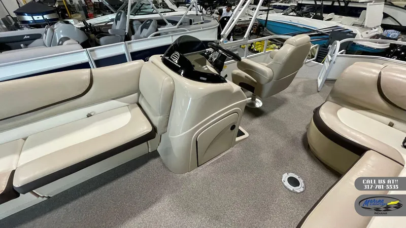 Slide: The Image of 2016 Sun Tracker Party Barge 22 DLX interior with beige seating and steering console. - 13