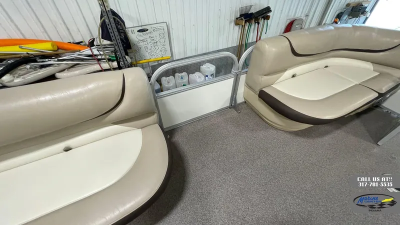 Slide: The Image of 2016 Sun Tracker Party Barge 22 DLX interior with beige seating and storage area. - 6