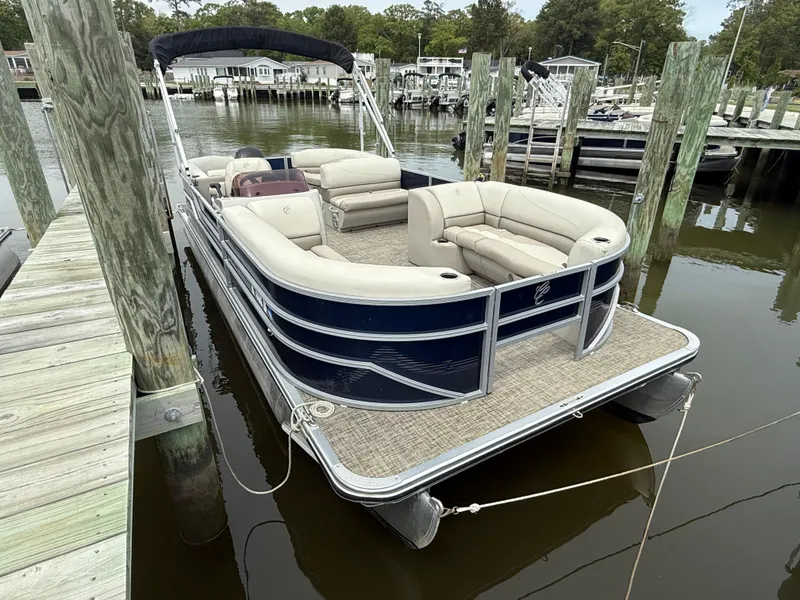 Slide: The Image of 2023 Cypress Cay Seabreeze 232 pontoon boat docked at marina, featuring spacious seating. - 2