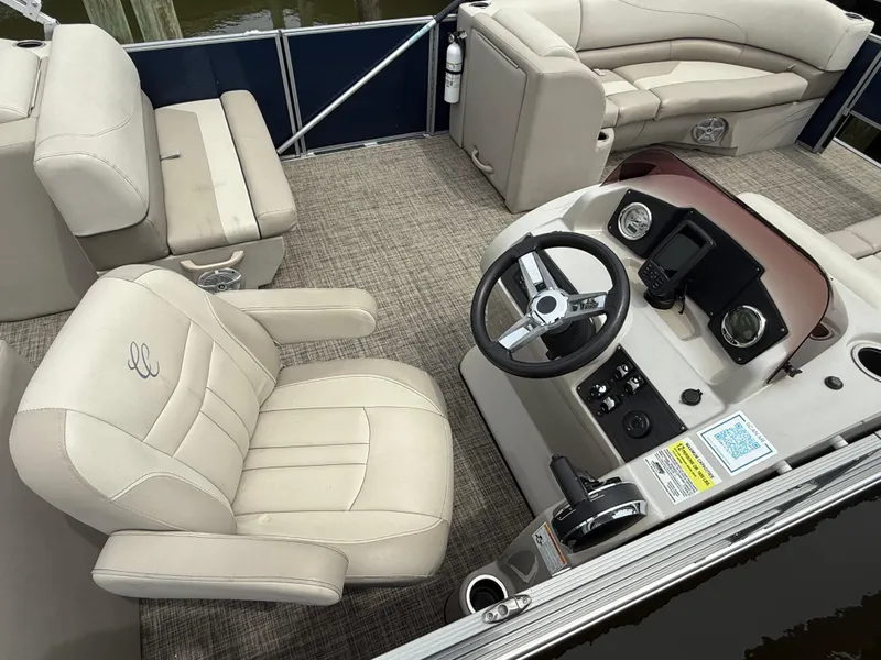 Slide: The Image of 2023 Cypress Cay Seabreeze 232 pontoon boat interior with beige seating and steering console. - 3