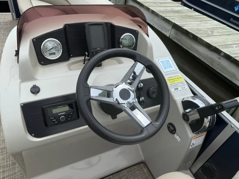 Slide: The Image of 2023 Cypress Cay Seabreeze 232 boat dashboard with steering wheel and controls. - 5