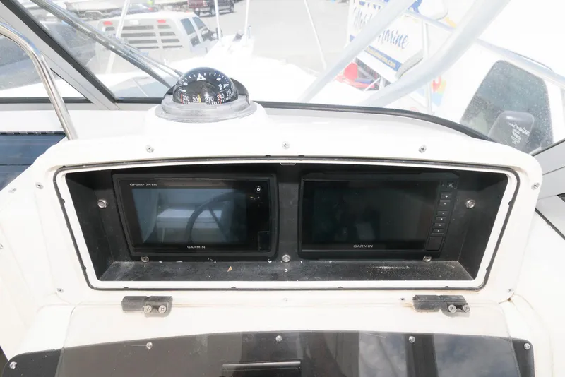Slide: The Image of Dashboard of 2001 Boston Whaler 23 Conquest with navigation screens and compass. - 10