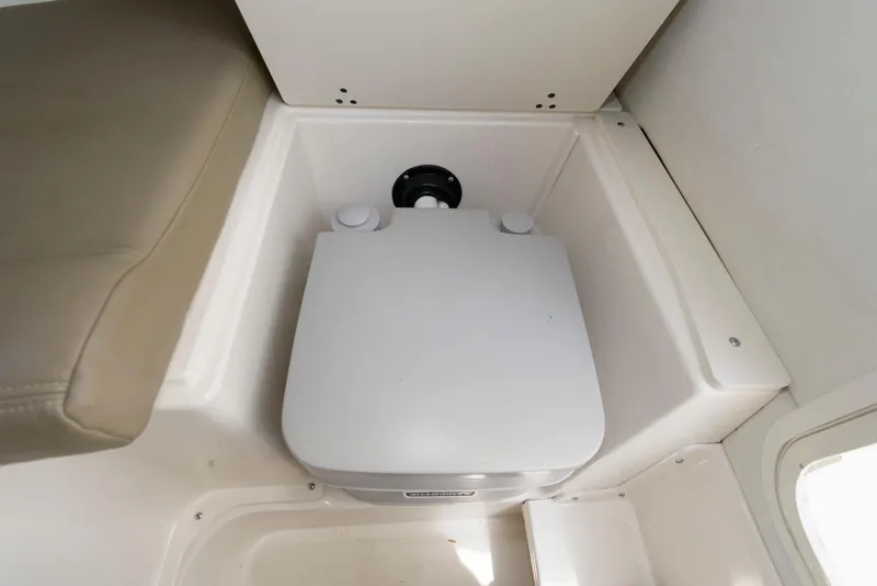 Slide: The Image of Interior of 2001 Boston Whaler 23 Conquest showing compact marine toilet setup. - 12