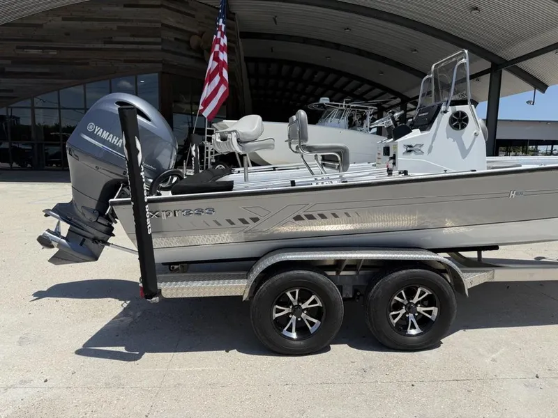 Slide: The Image of 2023 Xpress H22 Bay boat with Yamaha engine on trailer, parked outdoors. - 14