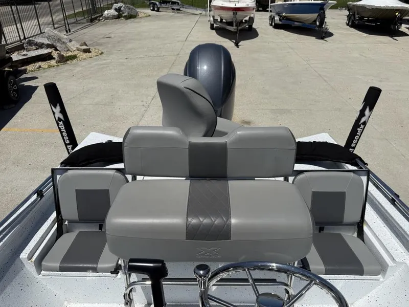 Slide: The Image of 2023 Xpress H22 Bay boat interior with gray seating and steering wheel. - 15