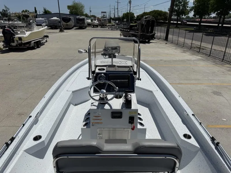 Slide: The Image of 2023 Xpress H22 Bay boat interior with steering console, parked in a lot. - 17