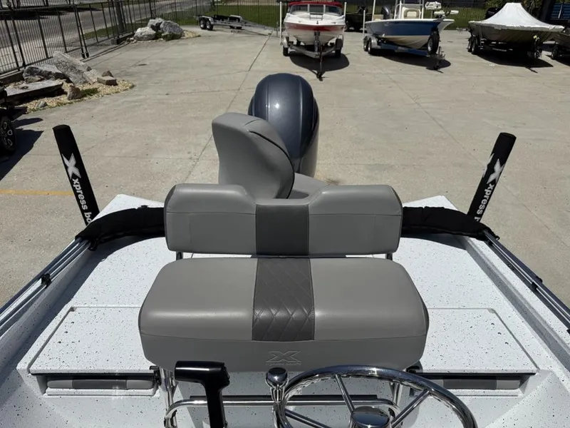 Slide: The Image of 2023 Xpress H22 Bay boat interior with gray seating and steering wheel. - 2