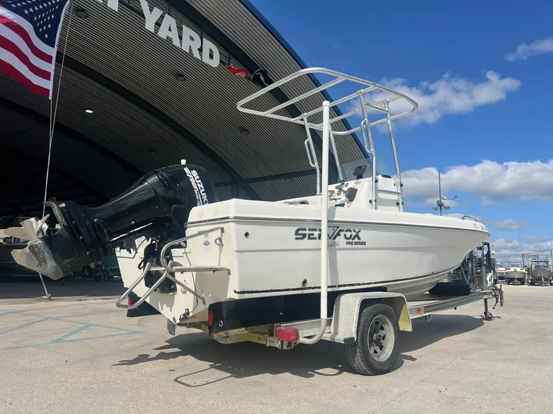Slide: The Image of 2007 Sea Fox Pro Series Center Console 197 on trailer, parked near a boatyard. - 3