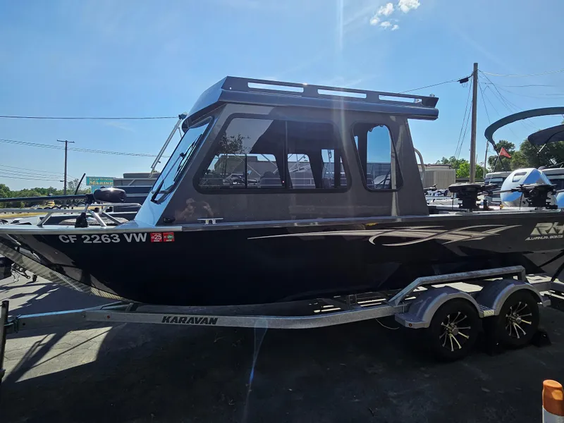 Slide: The Image of 2023 RH Boats 22 Coastal Hardtop on trailer, parked outdoors under clear sky. - 17