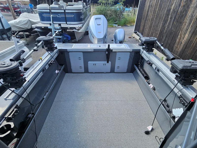 Slide: The Image of 2023 RH Boats 22 Coastal Hardtop interior with fishing equipment and motor, docked outdoors. - 20