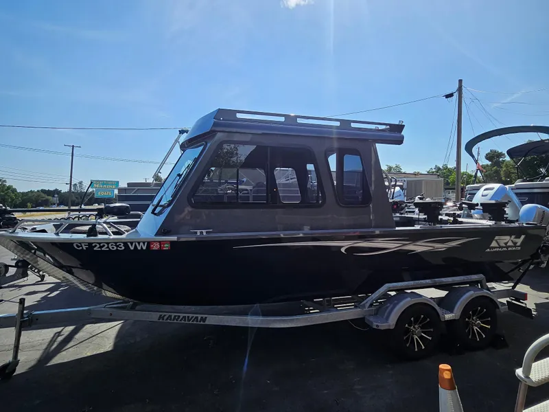 Slide: The Image of 2023 RH Boats 22 Coastal Hardtop on trailer, parked outdoors under clear sky. - 24