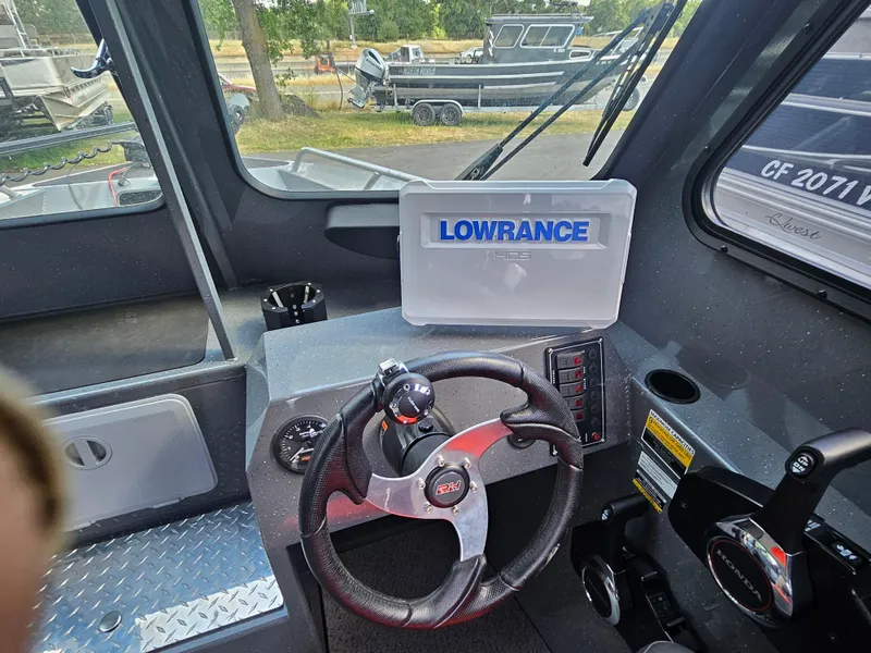 Slide: The Image of 2023 RH Boats 22 Coastal Hardtop interior with steering wheel and Lowrance navigation system. - 36
