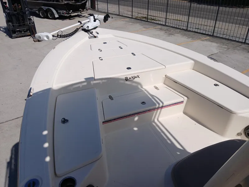 Slide: The Image of 2013 BlackJack 224 boat deck with storage compartments and trolling motor. - 14