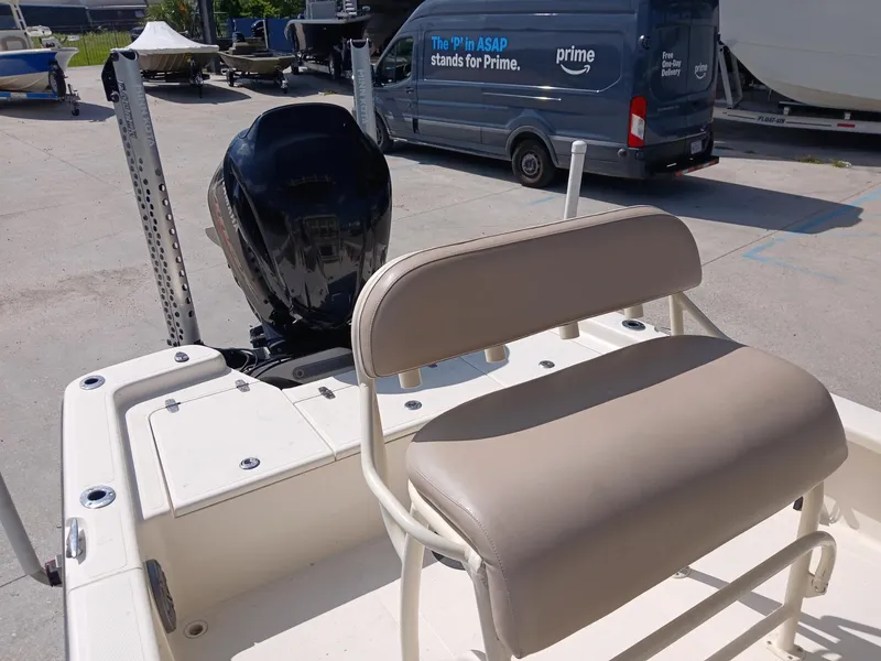 Slide: The Image of 2013 BlackJack 224 boat with beige seating and outboard motor in a marina. - 18