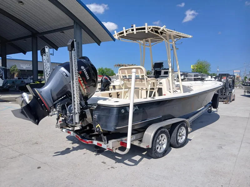 Slide: The Image of 2013 BlackJack 224 boat on trailer with Yamaha outboard motor, parked outdoors. - 2
