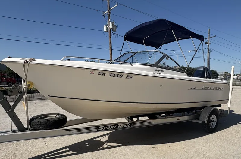 Slide: The Image of 2007 Sea Hunt Escape 200 boat on trailer with blue canopy, parked outdoors. - 10