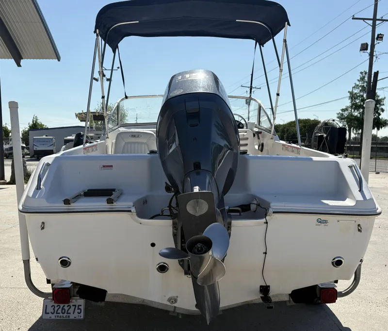 Slide: The Image of 2007 Sea Hunt Escape 200 boat with outboard motor and canopy, parked on a trailer. - 2