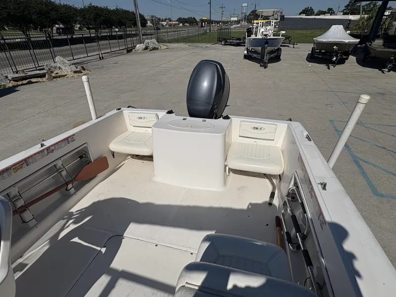 Slide: The Image of 2007 Sea Hunt Escape 200 boat interior with seating and motor, parked outdoors. - 4