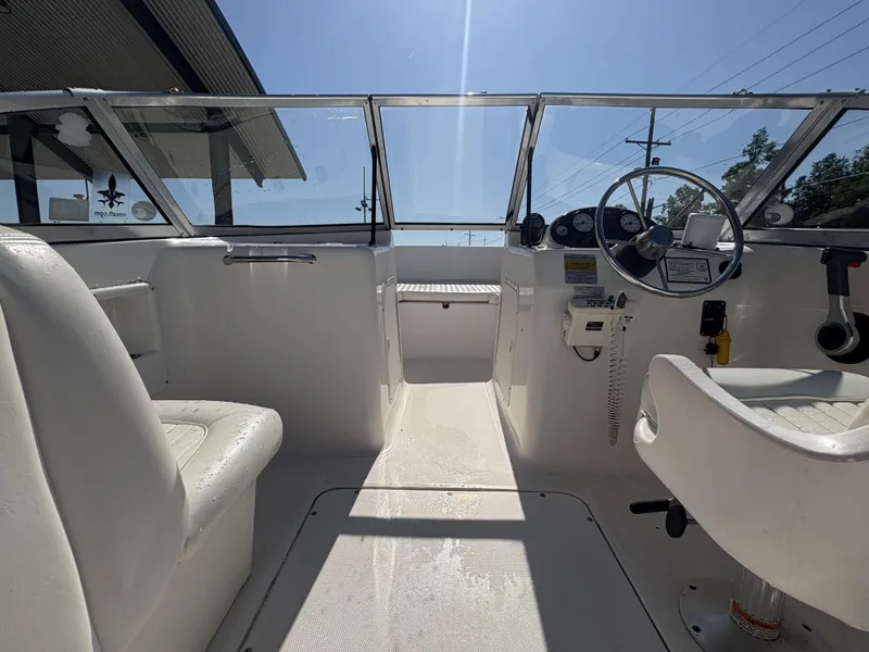 Slide: The Image of 2007 Sea Hunt Escape 200 boat interior with steering wheel and seating under clear blue sky. - 5