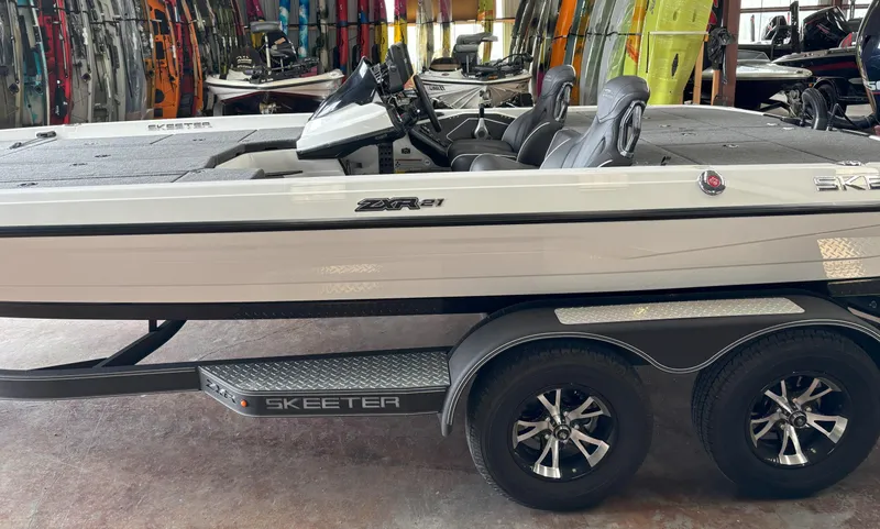 Slide: The Image of 2021 Skeeter ZXR21 boat on trailer in showroom, surrounded by colorful equipment. - 18