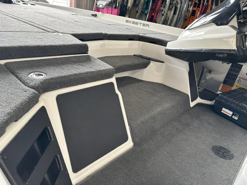 Slide: The Image of 2021 Skeeter ZXR21 boat interior with carpeted deck and storage compartments. - 22