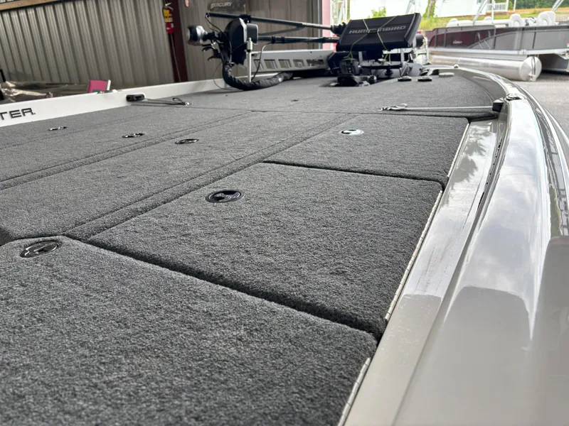 Slide: The Image of 2021 Skeeter ZXR21 boat deck with carpeted surface and fishing equipment. - 4