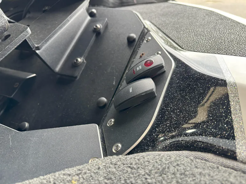Slide: The Image of Control panel of a 2021 Skeeter ZXR21 boat with switches and textured surface. - 5