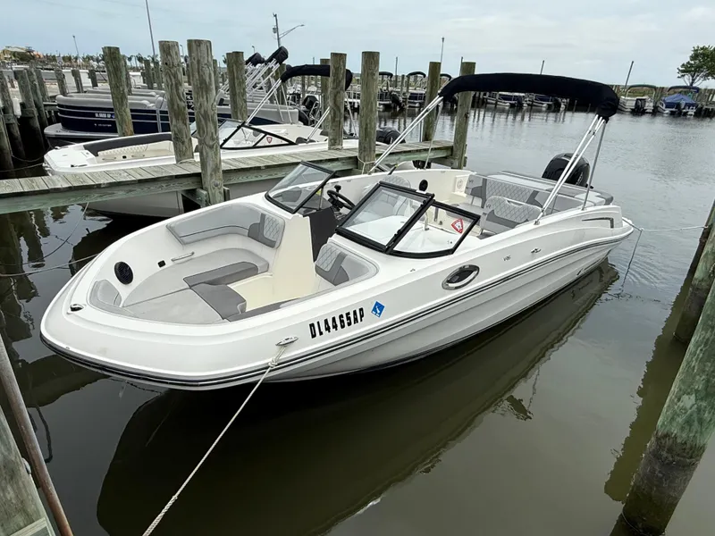 Slide: The Image of 2023 Bayliner VR6 Bowrider OB docked at marina, featuring sleek design and spacious seating. - 0