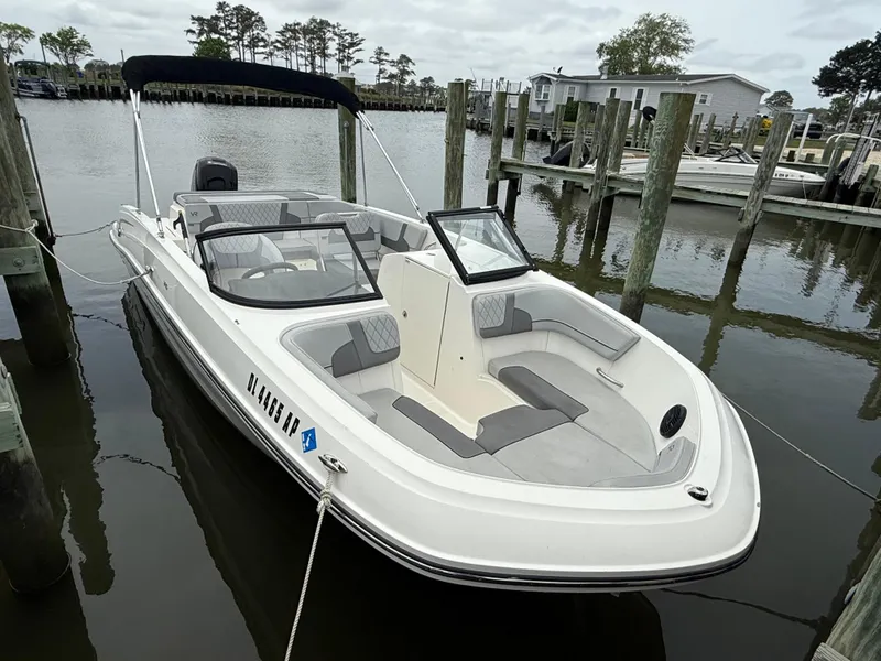 Slide: The Image of 2023 Bayliner VR6 Bowrider OB docked at a marina, featuring sleek design and spacious seating. - 2