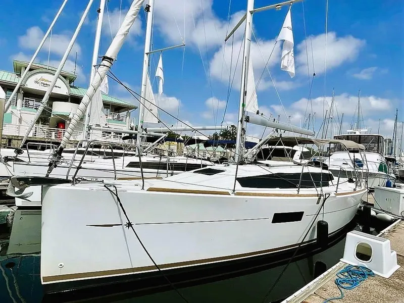 The Image of 2021 Jeanneau Sun Odyssey 319 sailboat docked at marina under blue sky. - 0
