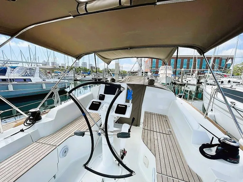 Slide: The Image of 2021 Jeanneau Sun Odyssey 319 sailboat cockpit with dual steering wheels, docked at marina. - 4